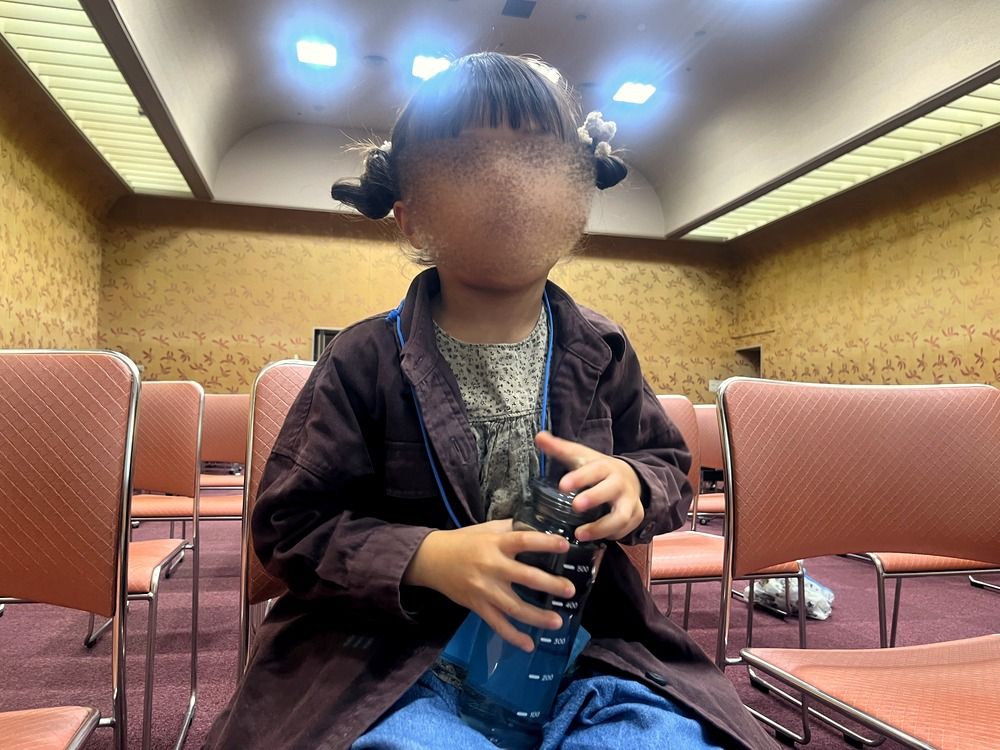 開始前の会場の椅子に座る5歳の子ども(顔はぼかし)