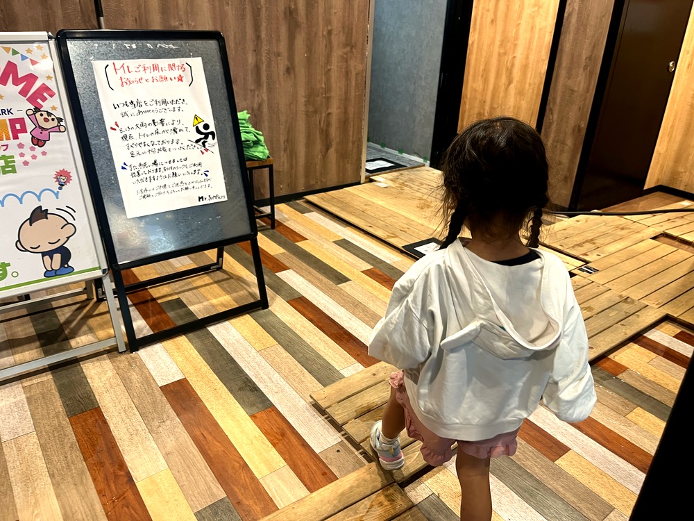 すのこの上を歩いてトイレに向かう子どもの後ろ姿