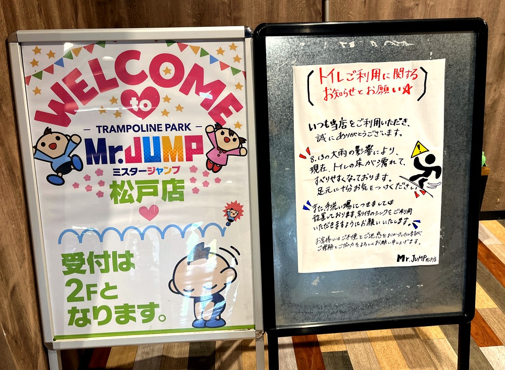 台風の影響でトイレの床が濡れていること、洗面台が仮設であることを知らせる店内の看板