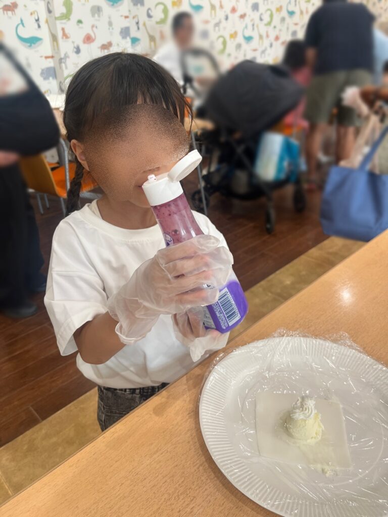 大福にブルーベリーソースをかける子ども