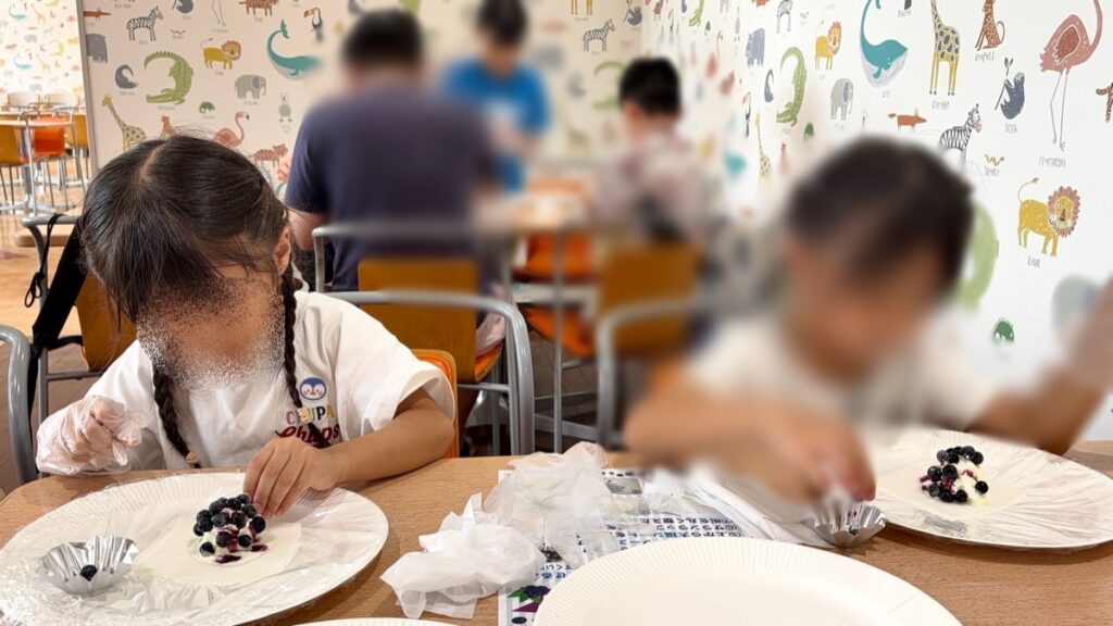 ブルーベリーをトッピングする子どもたち