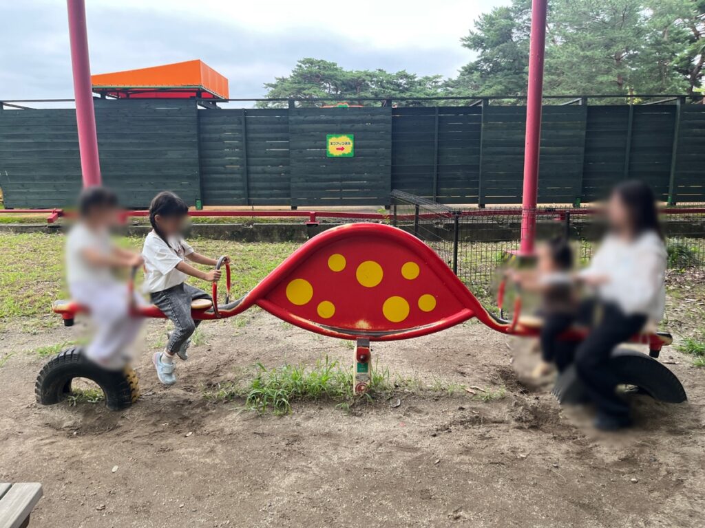 無料公園エリアのシーソーなどの遊具で遊ぶ子どもたち
