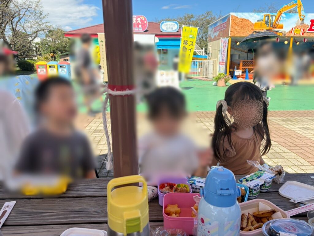 日陰のベンチでお弁当を食べる子どもたち